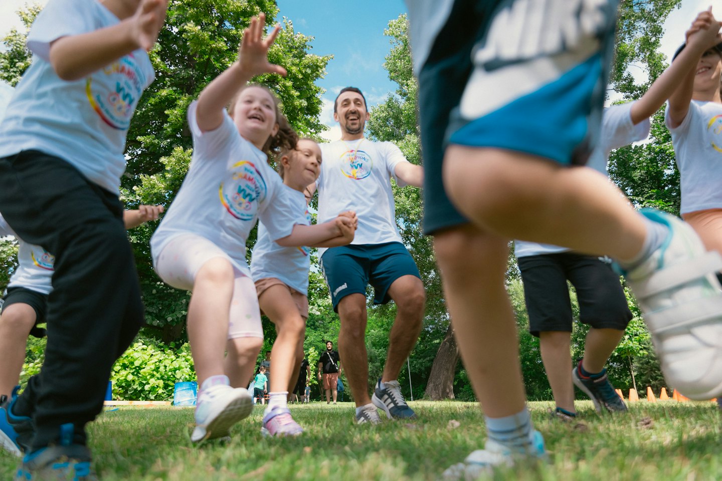 Een groep mensen in witte shirts die springen in een park.