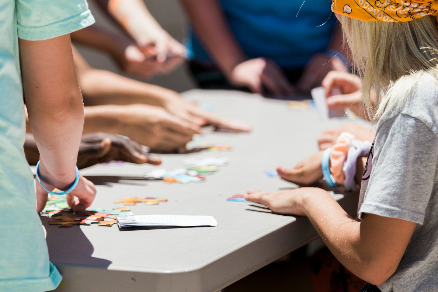 Diverse kinderen die samen aan een kleurrijke legpuzzel werken.