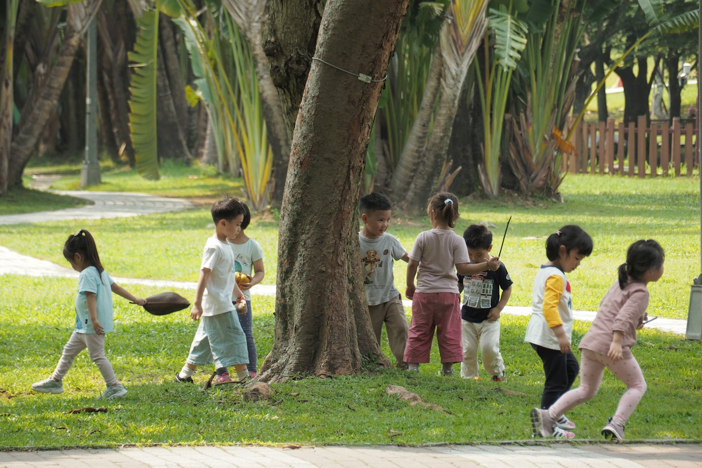 Kinderen spelen en ontdekken samen in een grasrijk park.